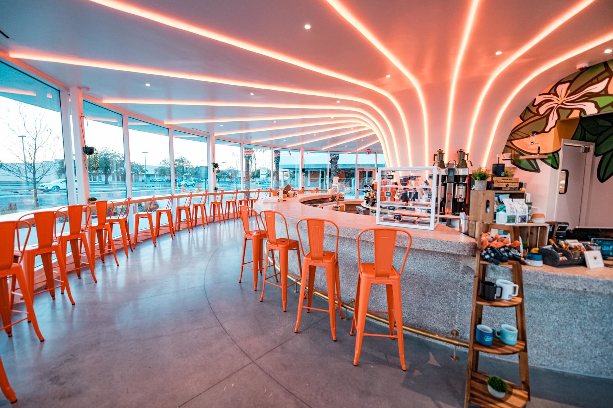 inside of the juice stand building with orange chairs and glass walls